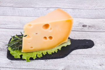 Maasdam cheese  in the board served salad leaves