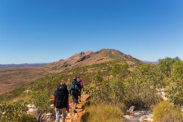 Fototapeta premium a group of Hikers on the way to the top of Mount Sonder just outside Alice Springs, West MacDonnel National Park, Australia