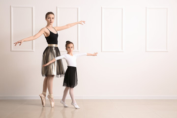 Fototapeta na wymiar Little ballerina training with coach in dance studio