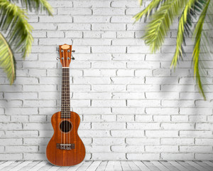 Fototapeta na wymiar Ukulele guitar on a white wall background. Concept of travel and lifestyle.