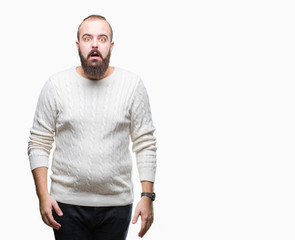 Young caucasian hipster man wearing winter sweater over isolated background afraid and shocked with surprise expression, fear and excited face.