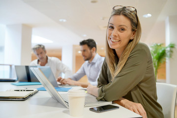 Female startup team member smiling at camera in office