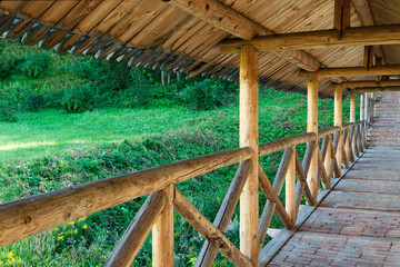 A long passage in the monastery on the background of wooden structures.