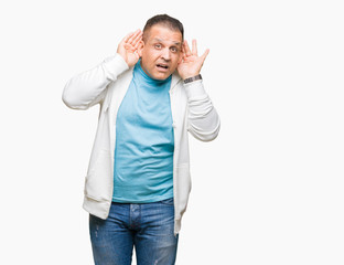 Fototapeta premium Middle age arab man wearing sweatshirt over isolated background Trying to hear both hands on ear gesture, curious for gossip. Hearing problem, deaf