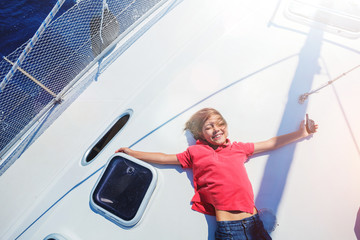 Little boy on board of sailing yacht on summer cruise. Travel adventure, yachting with child on family vacation.