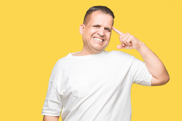 Middle age arab man wearig white t-shirt over isolated background Smiling pointing to head with one finger, great idea or thought, good memory