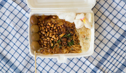 Bubur ayam is a porridge mixed with chicken meat served with egg and vegetables - Image