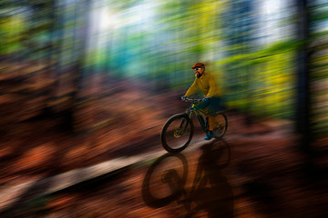 Fototapeta na wymiar Mountain biker riding on bike in spring mountains forest landscape. Man cycling MTB enduro flow trail track. Outdoor sport activity.