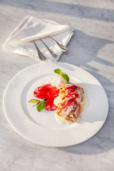 Apple strudel table raisins ice cream mint sultana berries sauce red green white plate close up top view