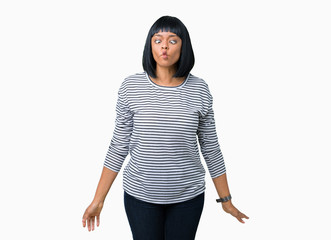 Beautiful young african american woman wearing stripes sweater over isolated background making fish face with lips, crazy and comical gesture. Funny expression.
