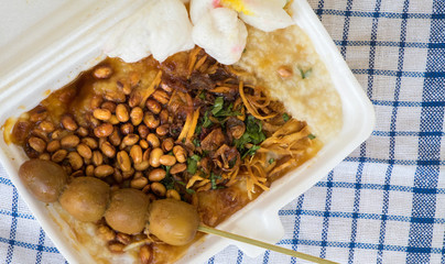 Bubur ayam is a porridge mixed with chicken meat served with egg and vegetables - Image