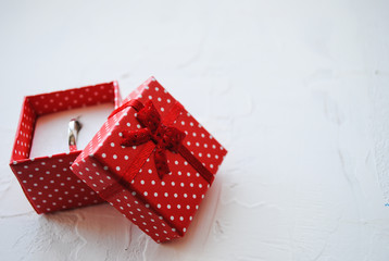 Red gift box with ring on white background