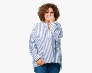 Beautiful middle ager senior woman wearing navy shirt over isolated background looking stressed and nervous with hands on mouth biting nails. Anxiety problem.