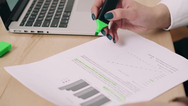 Woman holding document and identifies important text marker