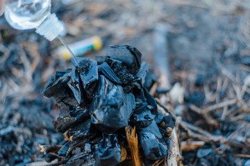Barbecue coals. Pouring liquid for ignition.