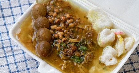 Bubur ayam is a porridge mixed with chicken meat served with egg and vegetables - Image