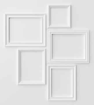 White photo frames on white wall with shadows