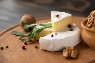 Fototapeta na wymiar Cheese camembert or brie with walnuts and arugula