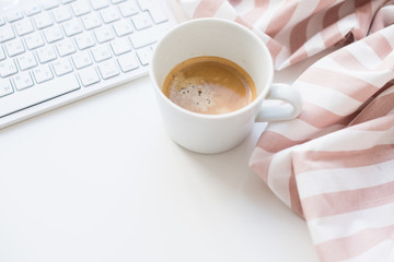 Fresh coffee and cloth with beige stripes on white background