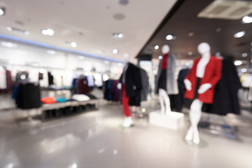 Fototapeta premium Beautiful blurred background of a women's clothing store in a mall. Defocused. Shopping mall or department store with blurred background and bokeh light.
