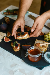 Food recipe concept. Toasts of cheese, Figs. Sandwiches with figs, cheese, honey and nuts on a shale board. Brochette with cheese and figs. Homemade