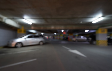 Blurred background underground parking for cars with arrows in the shopping center. Defocused image