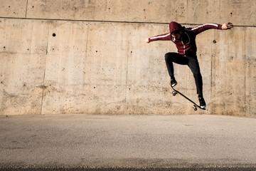 Man jumping and riding with a skateboard outdoors in a city © marc