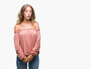 Fototapeta premium Beautiful young blonde woman over isolated background making fish face with lips, crazy and comical gesture. Funny expression.