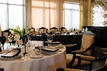 Wedding decor. Reception. Table number 1 on black wooden stand. Glasses and cutlery on side. Steampunk style