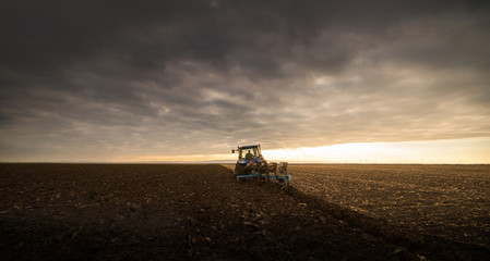 Farmer plowing stubble field