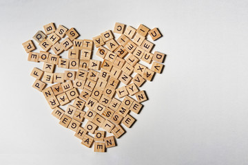 Alphabet letters on wooden square pieces forming heart shape - Powered by Adobe