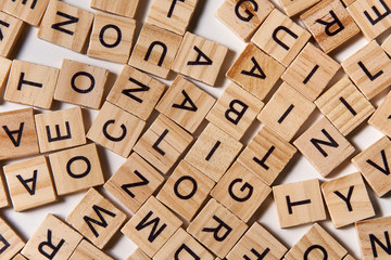 Alphabet letters on wooden scrabble pieces scattered - Powered by Adobe