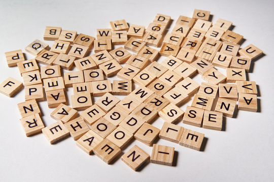 Alphabet letters on wooden scrabble pieces scattered