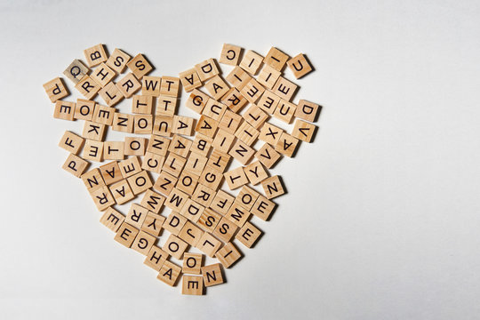 Alphabet letters on wooden square pieces forming heart shape