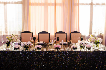 Wedding decor. Reception. Table number 1 on black wooden stand. Glasses and cutlery on side. Steampunk style