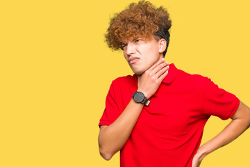 Fototapeta na wymiar Young handsome man with afro hair wearing red t-shirt Touching painful neck, sore throat for flu, clod and infection