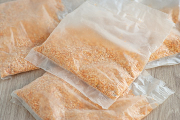 Packing cereals. Crushed peas in plastic packaging for cooking porridge. Many packages of cereals on the table.