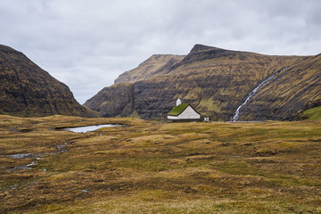 Mediaeval church with grass or turf roof in village Saksun or danish Saksen near the northwest coast of the Faroese island of Streymoy, in Sunda Municipality. Picture is taken in cloudy spring morning