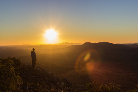 man enjoying sunset after a hike to the top of Mount Sonder just outside Alice Springs, West MacDonnel National Park, Australia