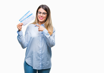 Young beautiful woman holding boarding pass over isolated background very happy pointing with hand and finger