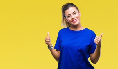 Young beautiful woman wearing casual blue t-shirt over isolated background success sign doing...
