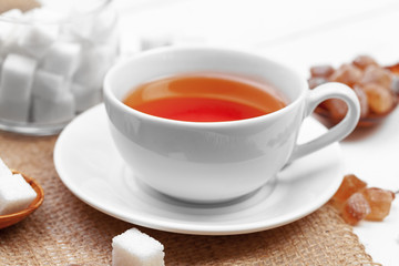 Glass cup of hot tea with sugar on the table