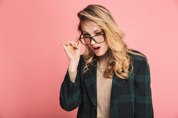 Portrait of cheeky blond woman 30s in stylish outfit and eyeglasses looking on camera