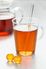 Glass of tea with yellow honey pearls