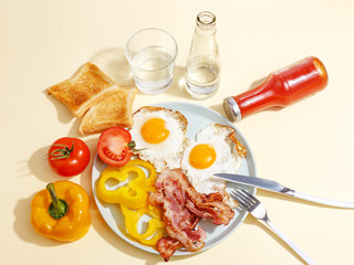 Simple breakfast. Fried egg with bacon, bell pepper and toast on a plate.