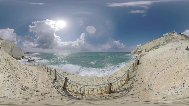 ROSH HANIKRA, ISRAEL - MARCH 12, 2017: 360 VR video. Tourists visiting natural landmark on the border of Israel and Lebanon. Landscape with sea waves crashing soft chalk rock. Man (with model release