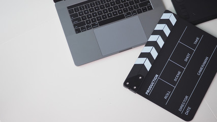 Fototapeta na wymiar Black Movie slate or clapperboard and laptop use in video production ,film, cinema industry on white background.