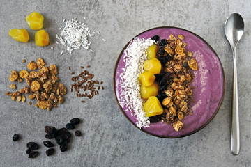 A colorful healthy breakfast of purple smoothies with granola and dried fruit.