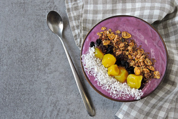 A colorful healthy breakfast of purple smoothies with granola and dried fruit.