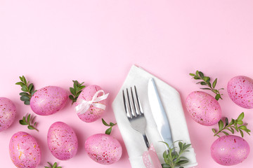 Easter. Pink Easter eggs and plate, knife and fork on a trendy pink background. Easter table setting. Happy easter. holidays. top view